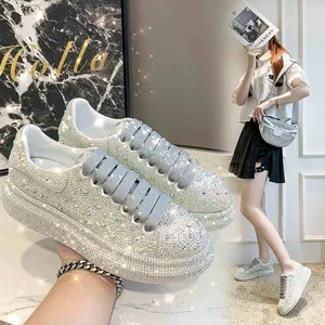 Detailed view of women's crystal-embellished platform sneakers with thick soles.