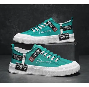 Side detail view of teal canvas men's platform sneakers with unique decorative labels