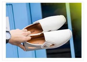 Detail view of white perforated men's leather loafers featuring a textured finish