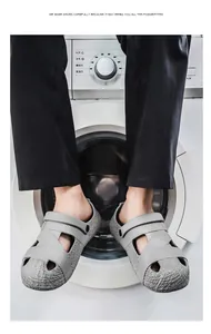 Detailansicht grauer Herren-Clogs mit Webstruktur vor einer Waschmaschine