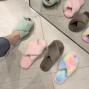 Close-up of colorful plush cross-strap slippers on tiled floor with mirror reflection