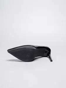 Detail view of black pointed toe stiletto heel and textured anti-slip sole structure.