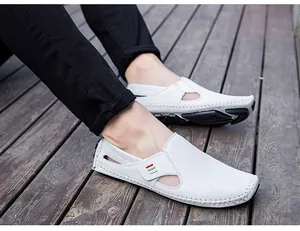Detail view of men's white slip-on loafers with breathable cutouts and pebbled texture.