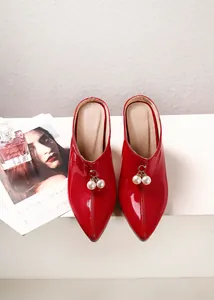 Detailed view of red patent leather pointed toe mules with elegant pearl bead charms