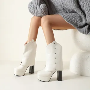 Vista detallada de botas blancas con plataforma y tacón grueso llevadas por una modelo.