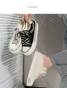 Detail of platform canvas sneakers with thick laces and striped soles in multi colors.