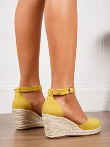 Detailed side view of women's yellow espadrille wedge sandals with buckle strap