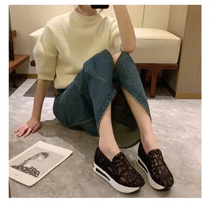 Detaillierte Lifestyle-Ansicht schwarzer Spitzen-Mesh-Plateau-Sneaker mit Jeansrock.