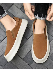 Braune Herren-Slip-On-Sneaker aus Wildleder mit dicker weißer Plateausohle am Fuß getragen