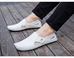 Men's white hollow casual loafers with hand-stitched detailing on wooden background