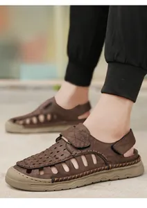 Close-up of men's brown breathable hollow-out beach sandals with stitch detailing.