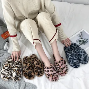 Detailed view of multiple colors of fuzzy leopard print cross-strap indoor slippers.