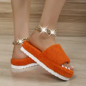 Detailed view of vibrant orange fuzzy slippers with thick white platform soles on model