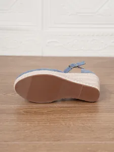 Detalle de la suela y el lateral de sandalias de cuña en denim azul y cuerda.