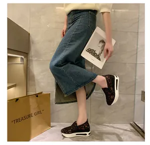 Detailansicht der schwarzen Damen-Keilsneaker aus Spitze mit Jeansrock und Oberteil