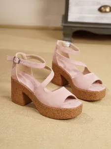 Primer plano de sandalias con plataforma de gamuza rosa con correa al tobillo y corcho