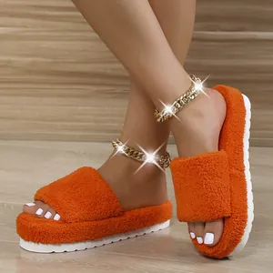 Detail view of orange fuzzy towel slippers with thick white sole on model feet