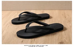 Detail view of men's durable black rubber flip-flops with anti-slip textured sole