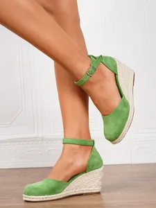 Side view detail of green suede wedge espadrilles with ankle straps and jute sole