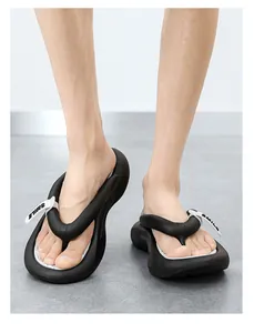 Stilvolle Ansicht von schwarzen EVA-Flip-Flops mit weißem 'SMILE'-Anhänger-Detail am Fuß