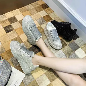Close-up detail of women's sparkly rhinestone platform sneakers with thick grey laces