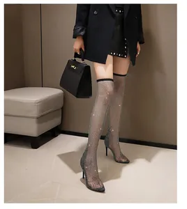 Detail van zwarte over-the-knee mesh laarzen met strassteentjes en hoge hakken