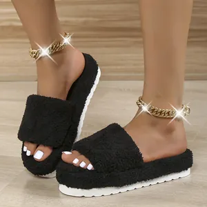 Stylish black fuzzy slides with thick white platform sole worn with gold anklets