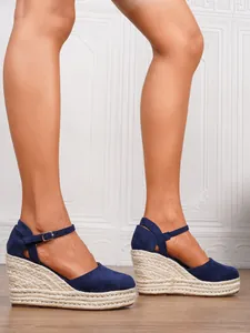 Seitenansicht von marineblauen Espadrilles-Keilsandaletten mit Knöchelriemen.
