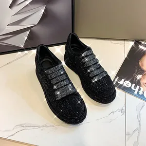 Close-up detail of black platform sneakers fully covered in shimmering silver rhinestones