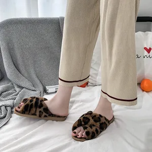Detailed shot of leopard print fuzzy cross-strap open-toe slippers worn in home setting