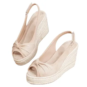 Elegantes sandalias de esparto con cuña en ante beige, puntera abierta y tira al tobillo.