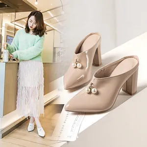 Elegant beige pointed toe block heel mules featuring stylish pearl charms for women