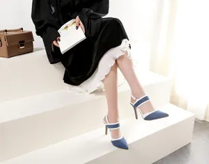Primer plano de sandalias elegantes de tacón alto en mezclilla con ribete blanco