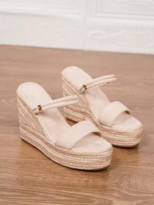 Detalle de sandalias de cuña tipo alpargata beige con suela de plataforma de cuerda