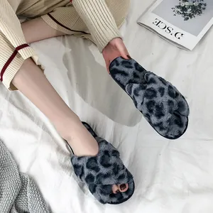 Close-up of fuzzy leopard print slippers with cross-over straps for indoor wear