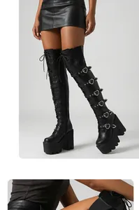 Détail des bottes cuissardes style punk avec boucles métalliques en forme de cœur.