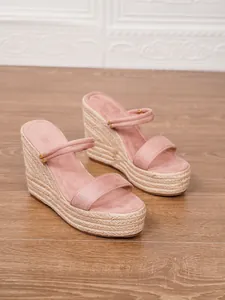 Vista macro de las correas de ante rosa y plataforma de yute de estas sandalias