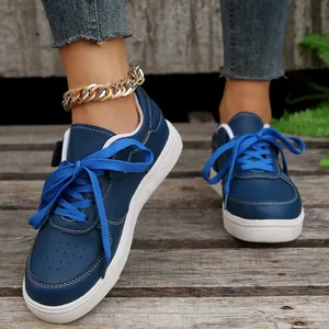 Detailansicht der marineblauen Damen-Sneaker mit leuchtend blauen Schnürsenkeln.