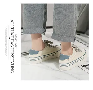 Close-up of thick-soled canvas sneakers with blue heel patch and side stripes