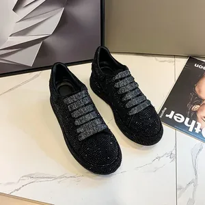 Detailed view of stylish women's low-top black sneakers covered in sparkling rhinestones.