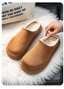 Close-up detail of brown suede slippers with thick white faux fur lining for winter.
