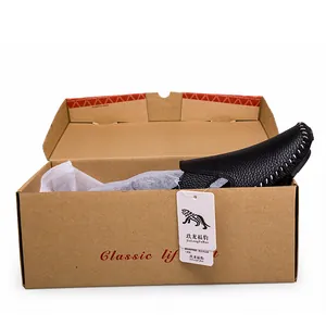 Close-up detail of black hand-stitched leather loafers presented in a classic shoe box