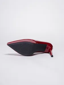 Detailed view of a red patent leather stiletto heel and textured anti-slip shoe sole