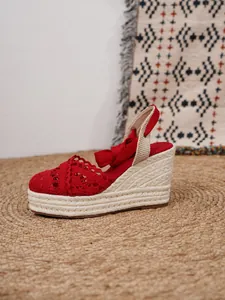 Detalle de sandalias de cuña tipo alpargata de encaje de ganchillo rojo
