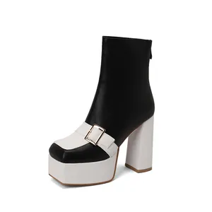 Close-up of black and white platform ankle boots with block heel and square toe