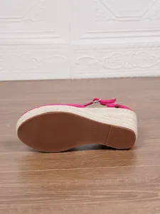 Detailansicht der Gummisohle und des geflochtenen Keilabsatzes der rosa Damensandale.