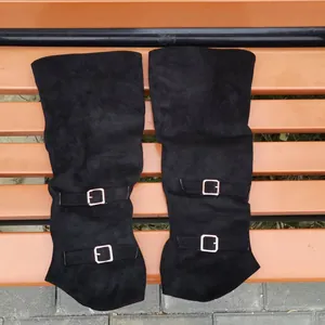 Detailed view of black suede over-the-knee boots with stylish silver buckle straps.