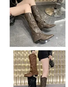 Detailopname van vintage bruine en zwarte laarzen met klinknagels gedragen door model