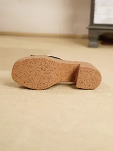 Vista detallada de la suela de una sandalia de cuña para mujer con plataforma de corcho