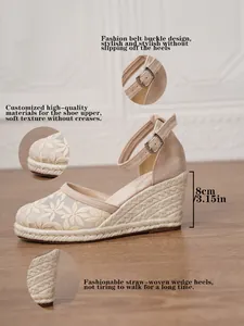 Detalle de sandalia con cuña color beige con bordado floral y tacón de paja trenzada